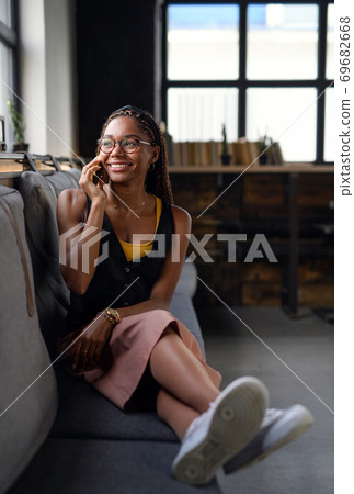 Portrait of young business woman indoors in office, using smartphone. 69682668