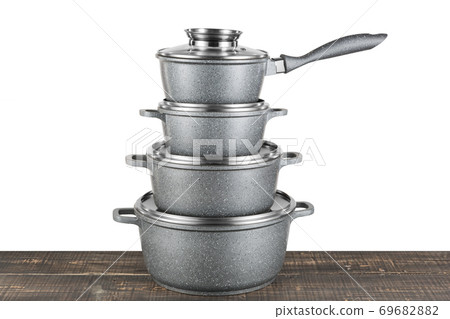 a set of gray enamel crockery stands in a pile on a wooden table, modern pots a set of gray enamel crockery stands in a pile on a wooden table, modern pots 69682882