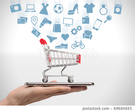 Online store. Collage of male hand holding mobile phone with shopping cart and pictograms of different household goods 69684893