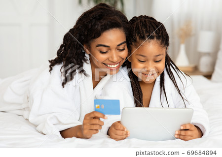 Happy Mom And Daughter Shopping Online With Digital Tablet And Credit Card Happy Mom And Daughter Shopping Online With Digital Tablet And Credit Card 69684894