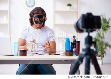 Young male cosmetician recording video for his blog Young male cosmetician recording video for his blog 69685886