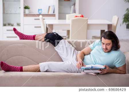 Young leg injured student studying at home Young leg injured student studying at home 69686429