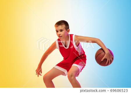 Full length portrait of a young basketball player with ball on gradient background 69686523