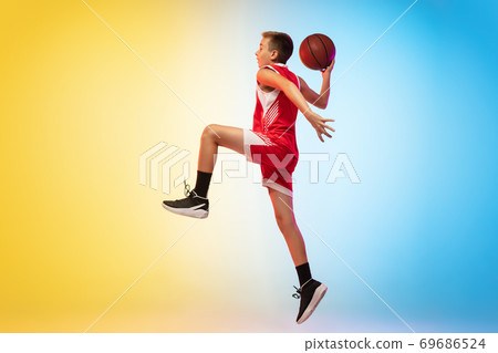Full length portrait of a young basketball player with ball on gradient background 69686524