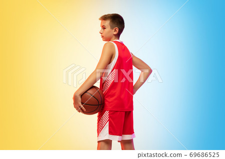 Full length portrait of a young basketball player with ball on gradient background 69686525
