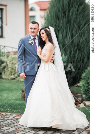 Romantic wedding moment, couple of newlyweds smiling portrait, bride and groom hugging Romantic wedding moment, couple of newlyweds smiling portrait, bride and groom hugging 69688430