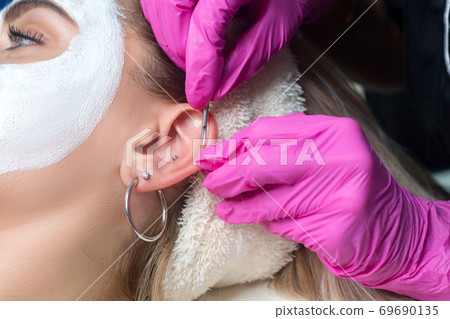 Helix piercing. Ear piercing procedure in the salon 69690135