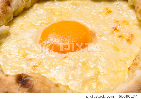 Adjarian Khachapuri closeup. Georgian national food. Focus on the yolk Adjarian Khachapuri closeup. Georgian national food. Focus on the yolk 69690174