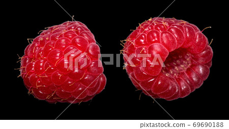 Two fresh ripe raspberry with water drops isolated on a black background. Macro shot. Two fresh ripe raspberry with water drops isolated on a black background. Macro shot. 69690188