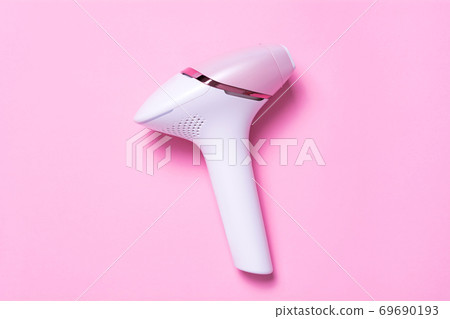 Photoepilator on a pink background. Hair removal tool. Photoepilator on a pink background. Hair removal tool. 69690193