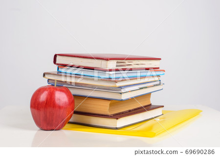 colorful Books and ripe Apple close on table on white background colorful Books and ripe Apple close on table on white background 69690286