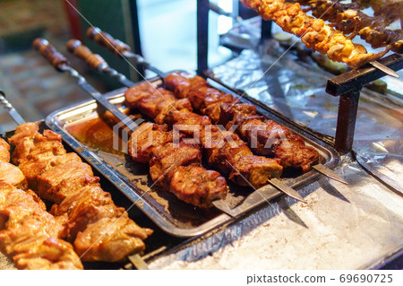 kababs are being grilled with heat in barbeque with metal skewers,at evening for sale as street food kababs are being grilled with heat in barbeque with metal skewers,at evening for sale as street food 69690725