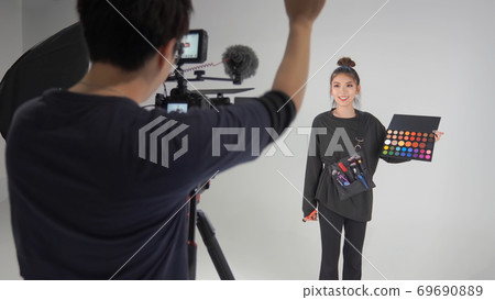 Video photographer instructing the subject to stand 69690889