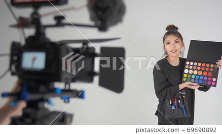 Hair and makeup artist explaining the procedure of makeup Hair and makeup artist explaining the procedure of makeup 69690892