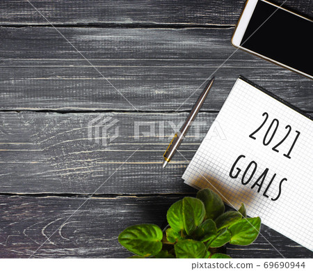 2021 Goals concept. Desktop with notebook, phone, pen. Motivation, inspiration. Planning, plans and tasks. New business ideas. Setting goal, target. 2021 Goals concept. Desktop with notebook, phone, pen. Motivation, inspiration. Planning, plans and tasks. New business ideas. Setting goal, target. 69690944