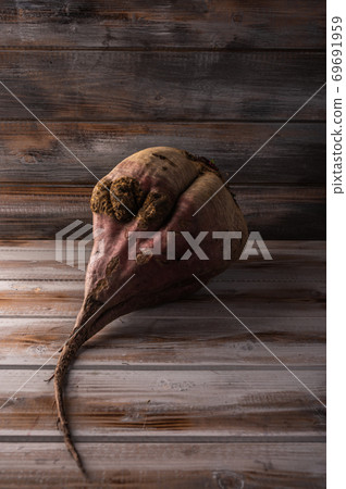 Big ugly organic ripe beetroot on a wooden background, close up Big ugly organic ripe beetroot on a wooden background, close up 69691959