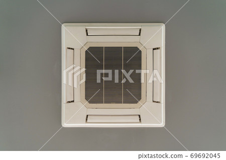 Modern white ceiling mounted cassette type air conditioner in office building system work. Ventilation compressor. 69692045