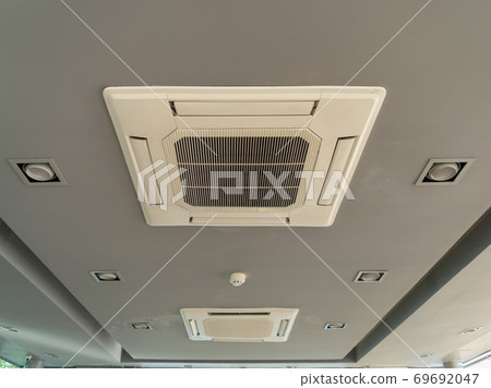 Modern white ceiling mounted cassette type air conditioner in office building system work. Ventilation compressor. 69692047
