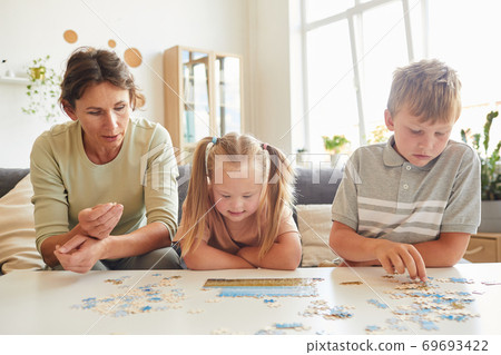 Girl with Down Syndrome Playing Puzzle Game with Family 69693422