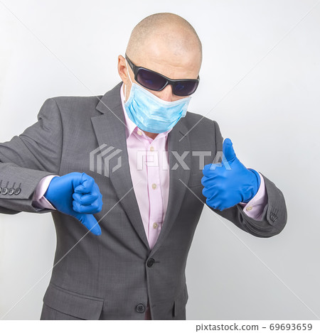 Business man in medical gloves, glasses and a protective mask. Business man in medical gloves, glasses and a protective mask. 69693659