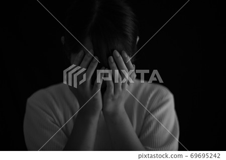 A woman who covers her face by hand 69695242