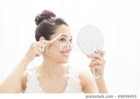 女人修剪她的眉毛 女人修剪她的眉毛 69699493