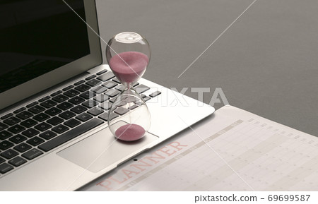 Hourglass on top of computer laptop and calendar planner 69699587