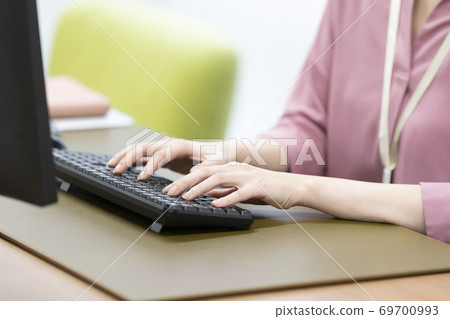 A woman's hand hitting the keyboard of a desktop computer A woman's hand hitting the keyboard of a desktop computer 69700993