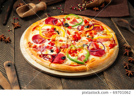 Pizza with salami and bell pepper on wooden table Pizza with salami and bell pepper on wooden table 69701062
