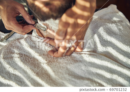 Customer of barbershop having his neck shaved with a razor Customer of barbershop having his neck shaved with a razor 69701232