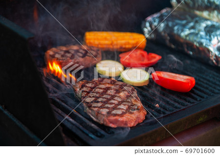 Beef steaks on the grill with flames 69701600