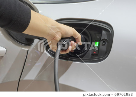 Close-up asia men hands who are fueling a new vehicle electrification via rechargeable electricity machine 69701988