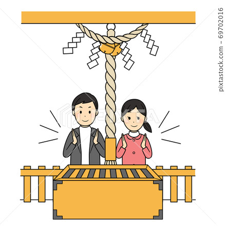 Two people worshiping at a shrine 69702016