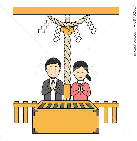 Two people worshiping at a shrine 69702017