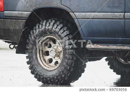 Wheel closeup in a countryside landscape with a muddy road. Wheel closeup in a countryside landscape with a muddy road. 69703056