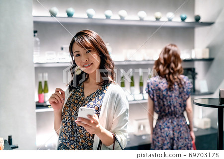 有智能手機的一個少婦享受與朋友的購物 69703178