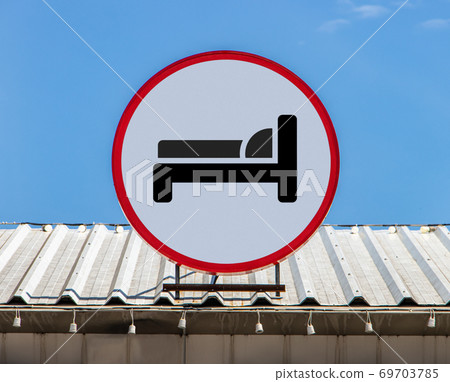 A Circle billboard with icon a symbol bedroom of hotel, is installed on a roof.  69703785
