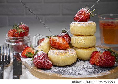 Cheese pancakes, homemade traditional Ukrainian and Russian syrniki with strawberries  on wooden background. 69705095