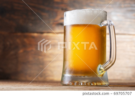 mug of beer on a wooden background 69705707