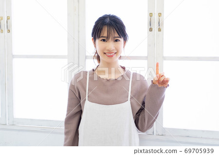 Young woman showing point with forefinger Young woman showing point with forefinger 69705939