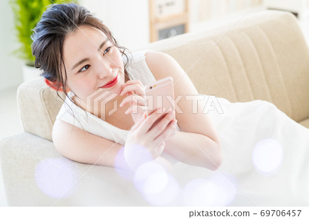 Women's smartphone living room cute lifestyle 69706457