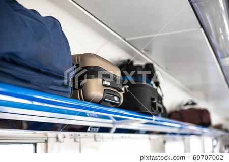 Holiday vacation, tourism, travel, modern train interior, of railway transportation concept. Luggage on shelf railway train. Holiday vacation, tourism, travel, modern train interior, of railway transportation concept. Luggage on shelf railway train. 69707002