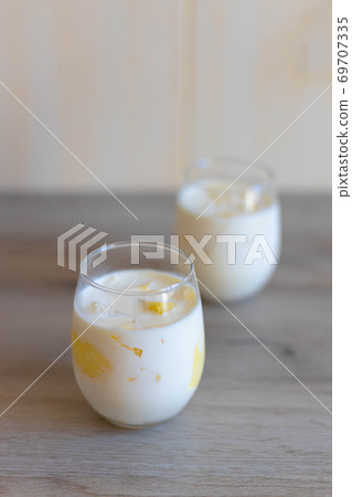 Delicious sweet cream ice cream dessert with melon in glasses on wooden background. Vertical photo 69707335