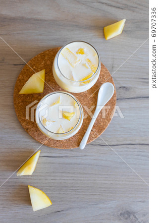 Delicious sweet cream ice cream dessert with melon in glasses on wooden background 69707336