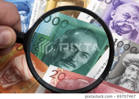 Kyrgyzstani som in a magnifying glass a business background Kyrgyzstani som in a magnifying glass a business background 69707467