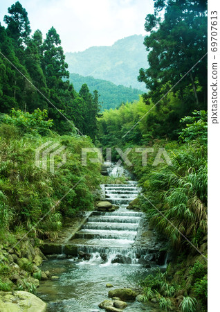 The small waterfall in the flowing water found in the mountains is really beautiful The small waterfall in the flowing water found in the mountains is really beautiful 69707613