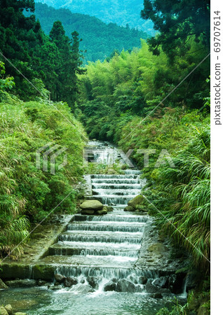 The small waterfall in the flowing water found in the mountains is really beautiful 69707614