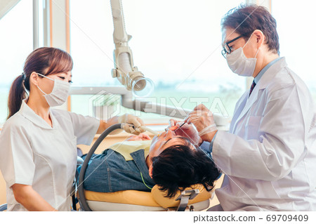 Dental hygienist and male patient Dental hygienist and male patient 69709409