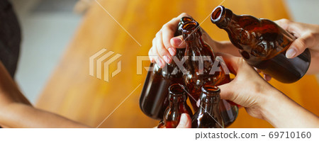 Hands of young friends, colleagues during beer drinking, having fun, laughting and celebrating together. Flyer with copyspace Hands of young friends, colleagues during beer drinking, having fun, laughting and celebrating together. Flyer with copyspace 69710160