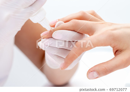 Manicurist uses manicure tool. 69712077